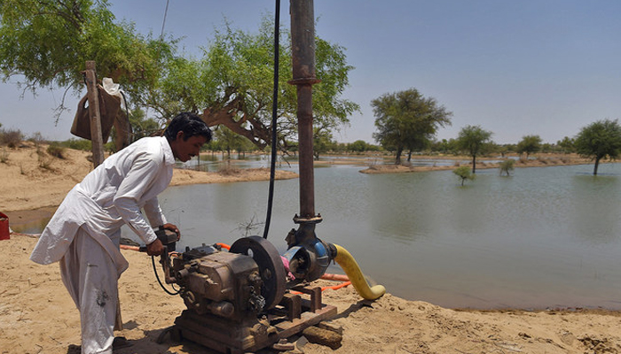 A representational image showing a worker starting a water drawing pump at a site to store water in in the Tharparkar. — AFP/File