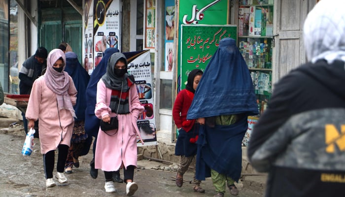 Afghan women walk along a street at a market in the Fayzabad district of Badakhshan province on December 12, 2023. — AFP