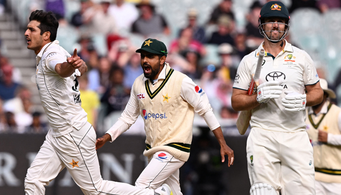 Pakistan bowler Mir Hamza (L) celebrates with teammate Barbar Azam (C) after dismissing Australian batsman Mitch Marsh (R) on the third day of the second cricket Test match between Australia and Pakistan at the Melbourne Cricket Ground (MCG) in Melbourne on December 28, 2023. — AFP