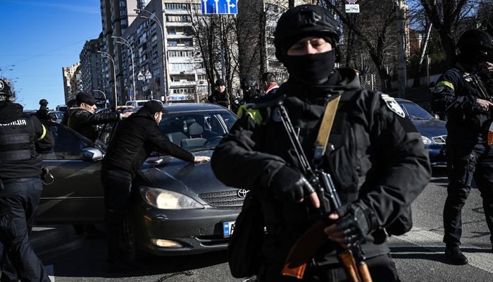Ukrainian policemen stop cars to control people as they look for suspicious men, in  Kyiv on February 27, 2022. — AFP
