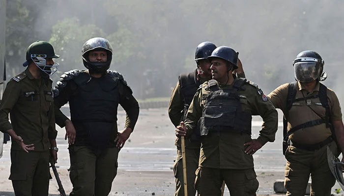 Policeman stand guard as Pakistan Tehreek-e-Insaf party activists and supporters of former Pakistan´s Prime Minister Imran Khan protest against the arrest of their leader, in Lahore on May 11, 2023. — APP