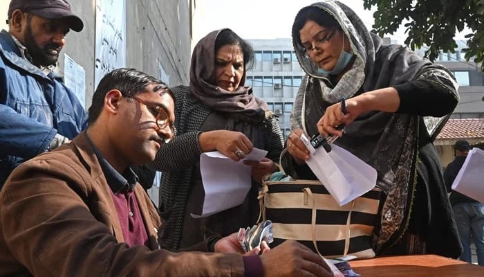Candidates for the seats reserved for women of a provincial assembly receive their nomination papers for the upcoming general election at the election commission office in Lahore on December 20, 2023. — AFP