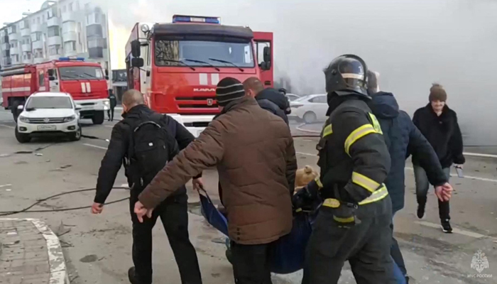 People evacuate an injured person after shelling in Belgorod, about 30 kilometers (19 miles) from the border with Ukraine on December 30, 2023. — AFP