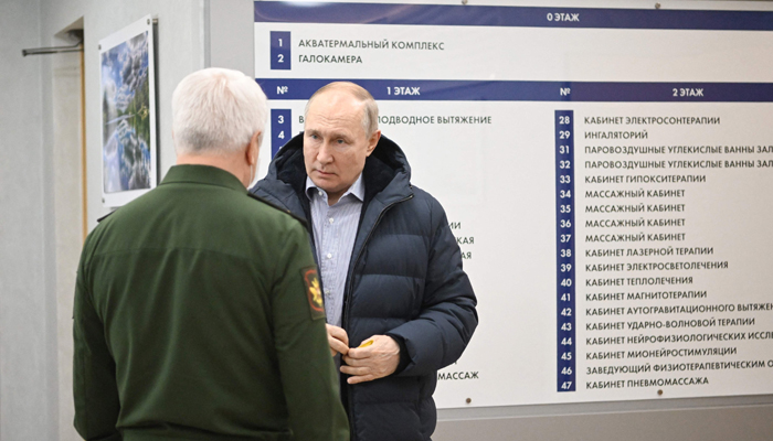 This photograph shows Russias President Vladimir Putin visiting the Central Vishnevsky Military Clinic in Moscow on January 1, 2024. — AFP