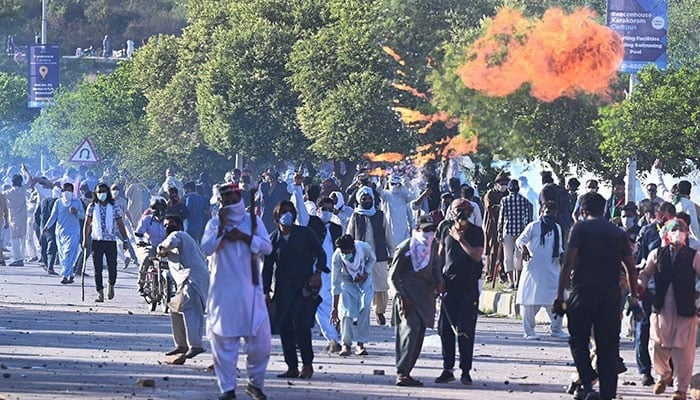 People clash with police during a protest outside the police headquarters where Imran Khan was in custody, in Islamabad on May 10, 2023. —AFP