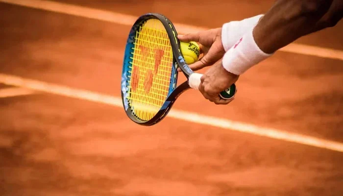 A representational image of a person preparing to take a shot during a tennis match. — Pexels