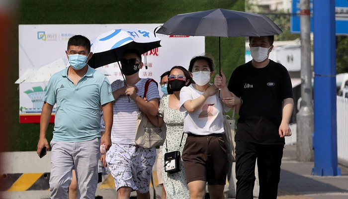 People walk on the street amid high temperatures in Minhang District of east Chinas Shanghai. — Xinhua