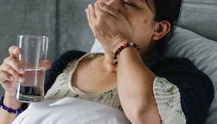 This representational image shows an influenza-affected patient taking medicine. — Pexels