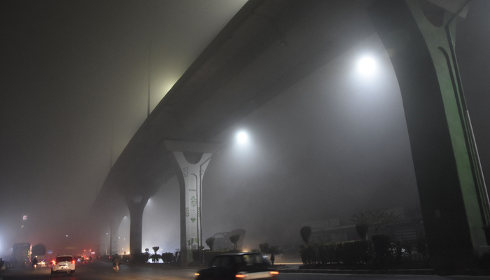 Commuters make their way during heavy fog at Murree Road during night hours in Rawalpindi on January 03, 2024. — Online