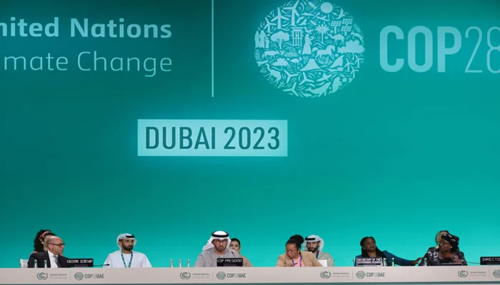 President Sultan Ahmed Al Jaber (C) and UN Framework Convention on Climate Change Executive Secretary Simon Stiell (L) and other officials attend a plenary session during the UN climate summit in Dubai on December 13, 2023. — AFP