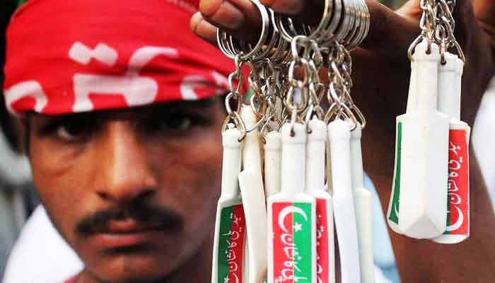 Man selling keychains of PTI party symbol bat in Lahore. —Online/file