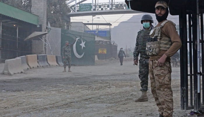 Afghan security personnel (R) and Pakistani border policemen stand guard at the zero point Torkham border crossing between Afghanistan and Pakistan, in Nangarhar province on December 6, 2023. — AFP