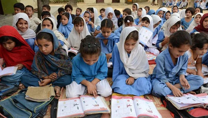 The picture shows school girls studying. — AFP
