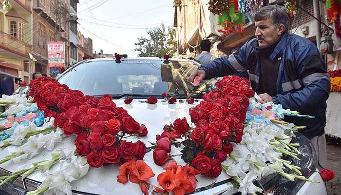 This undated image shows a vendor decorating a vehicle for a wedding ceremony. — APP