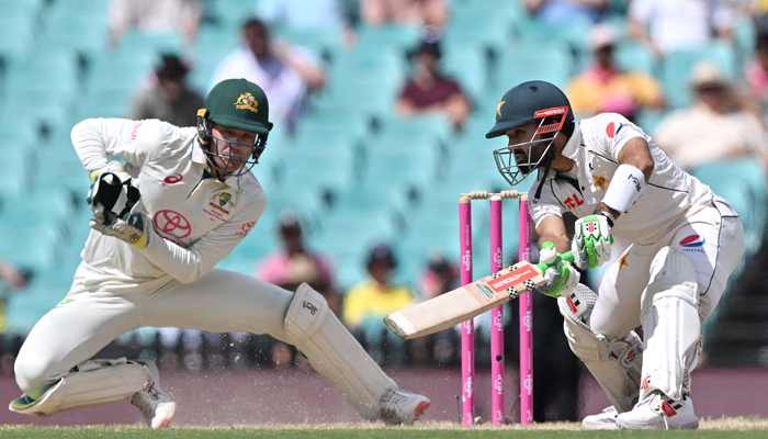 Pakistans Mohammad Rizwan plays a shot as Australias wicketkeeper Alex Carey (L) follows the ball during day four of the third cricket Test match between Australia and Pakistan at the Sydney Cricket Ground in Sydney on January 6, 2024. — AFP