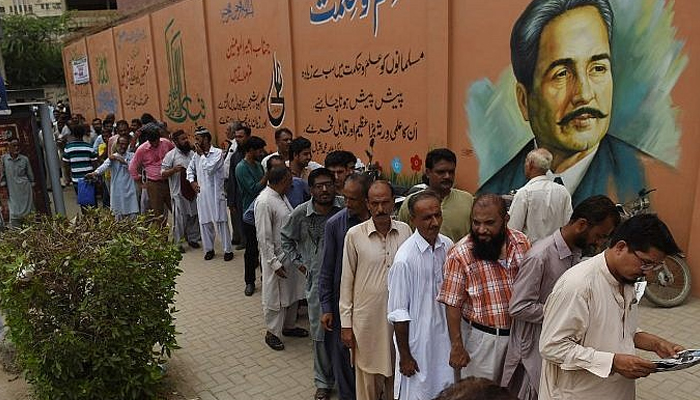 People in Pakistan stand in a queue during the general elections in Karachi. — AFP/File