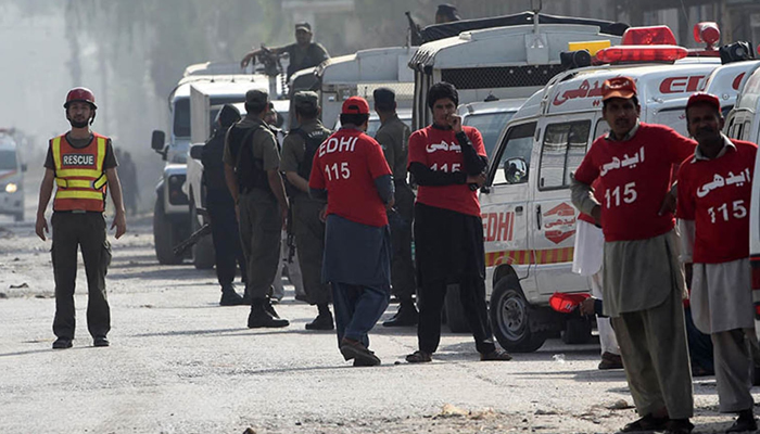 This image shows rescue officials standing outside an area where a blast occurred in KP. — AFP/File