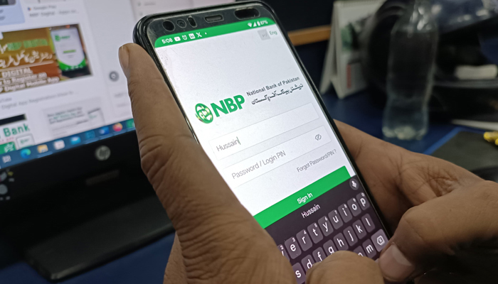 This image taken on December 16, 2023, shows a person using a digital mobile application of the National Bank of Pakistan in Karachi. — Geo.tv
