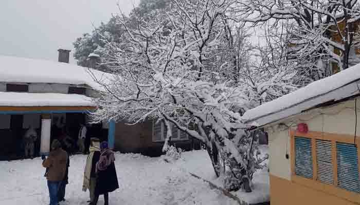 Tourists while enjoying the snowfall in Murree. — Online