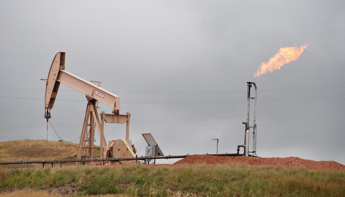 This image shows an oil pump and a gas field. — AFP/File