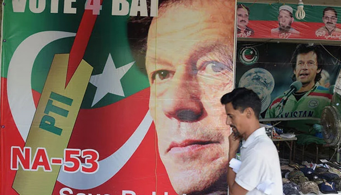 A man walks past a poster of ex-prime minister Imran Khan, at a market in Islamabad. — AFP/File
