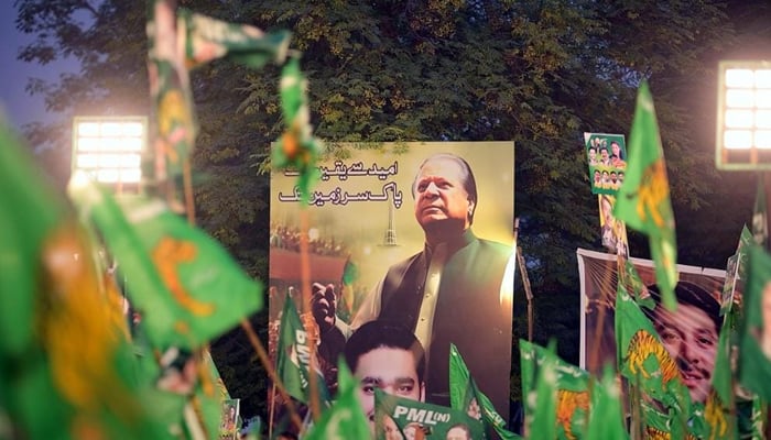 Pakistan Muslim League-Nawaz (PMLN) supremo Nawaz Sharifs picture can be seen on a Pena flex with party supporters holding flags in this image on October 8, 2023. — Facebook/Maryam Nawaz Sharif