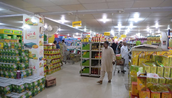 People buy food items at a utility store in Islamabad. — AFP/File