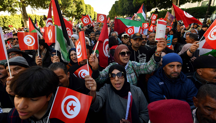 Tunisians wave national flags during a protest marking the 14th year of the 2011 revolution on Habib Bourguiba Avenue in Tunis on January 14, 2024. — AFP