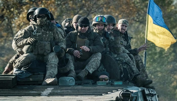 Ukrainian soldiers ride on an armored vehicle in Novostepanivka, Kharkiv region on  September 19, 2022. — AFP