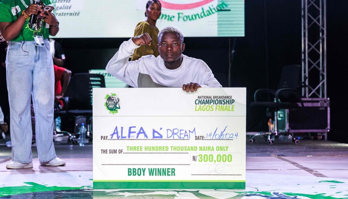 Salaam Idris Oluwaseun, aka B-boy Alfa, poses with his winner check after winning the National Breakdance Competition held at the National Stadium Surulere in Lagos on January 15, 2024.— AFP