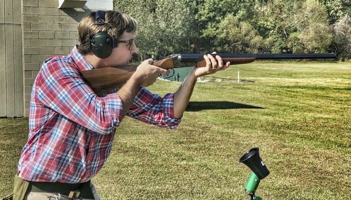 This representational image shows a man playing a shot in firing range. — Unsplash