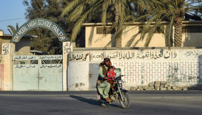 A motorcyclist rides past a high school in Panjgur district in Balochistan province on January 17, 2024. Pakistan recalled its ambassador from Iran on January 17, 2024. — AFP