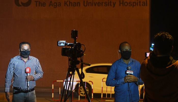 Pakistani journalists wearing protective facemasks report outside the Aga Khan University Hospital. —AFP/File
