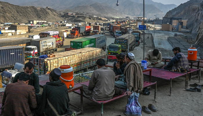 Drivers take a rest as stranded trucks are pictured near the Pakistan-Afghanistan border in Torkham on January 16, 2024. — AFP