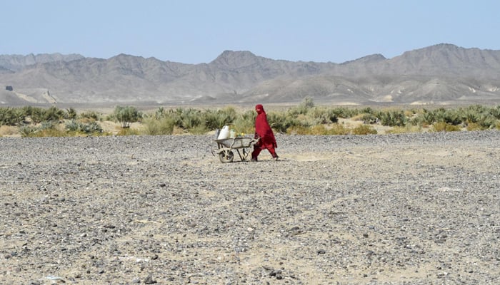 A woman carries water cans in a wheelbarrow at the Koh-e-Sabz area of Pakistan´s south-west Baluchistan province where Iran launched an airstrike, on January 18, 2024. — AFP