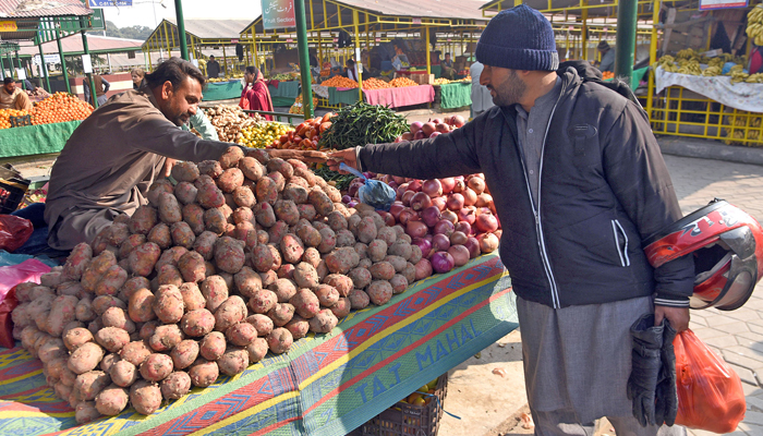 A man is buying vegetables from a vendor at the Weekly Friday Market of Sector G-6 in Islamabad on January 5, 2024. — Online