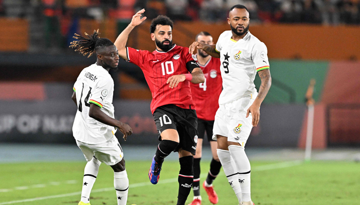 Egypts Mohamed Salah fights for the ball with Ghanas Gideon Mensah and Jordan Ayew during the Africa Cup of Nations 2024 group B football match at the Felix Houphouet-Boigny Stadium in Abidjan on January 18, 2024. — AFP