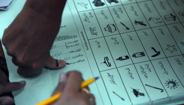 This photo shows a female voter pressing her inked thumb onto a ballot paper at a polling station in Islamabad. — AFP/File