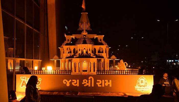 People stand near a wooden replica of the Ayodhya Ram temple, in Ahmedabad on January 19, 2024. — AFP