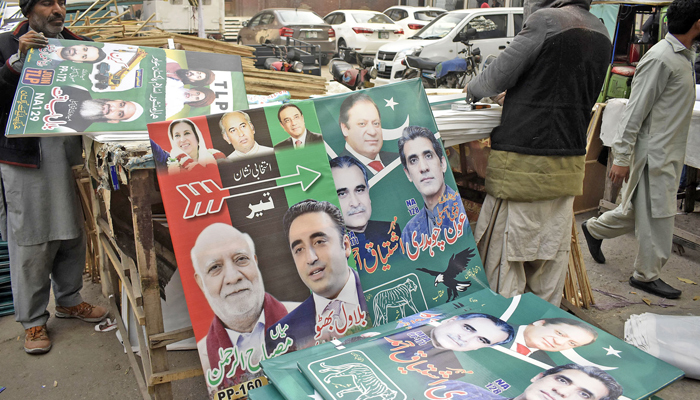 Workers preparing election campaign posters of political parties at a printer, ahead of the upcoming general elections in lahore. — Online/File