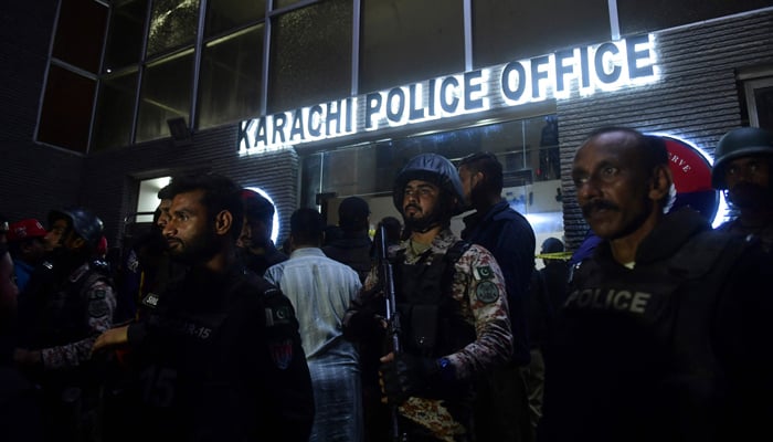 Security personnel stand guard outside a police compound after it was attacked by terrorists in Karachi on February 17, 2023. — AFP