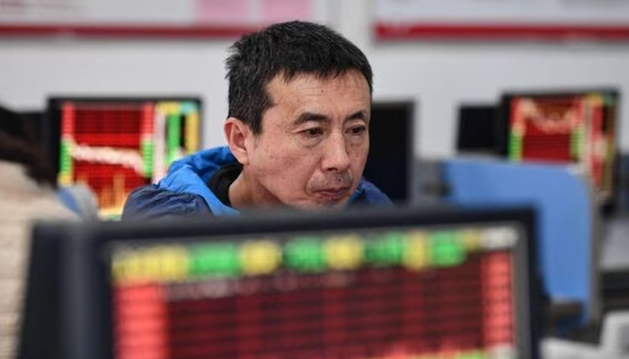 An investor looks at screens showing stock market movements at a securities company in Fuyang in Chinas eastern Anhui province on January 17, 2024. — AFP