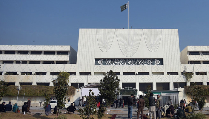 Pakistani security and media officials gather in front of the Parliament House building in Islamabad. — AFP/File