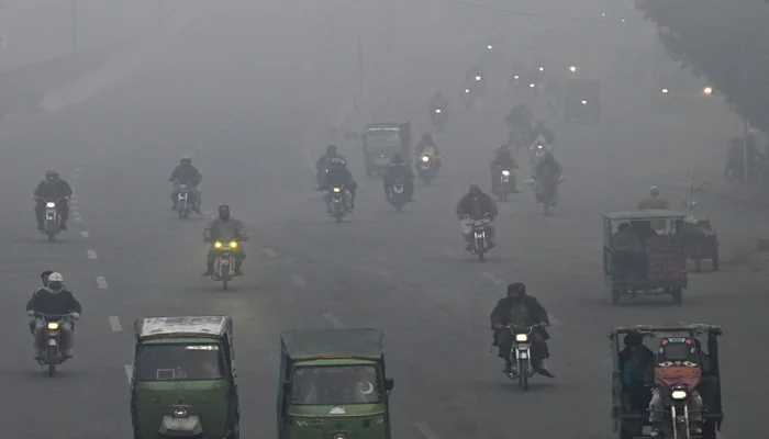Motorcycles are moving on their way in heavy fog in Lahore.. — AFP/File