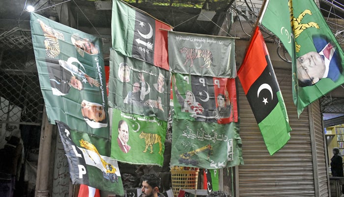 A vendor displaying political parties flags attraction for customers outside his shop in the Ganpat area in the Provincial Capital, ahead of the countrys general elections in 2024. — Online/File