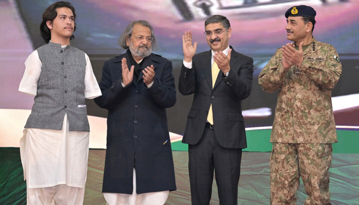 Caretaker Prime Minister Anwaar-ul-Haq Kakar (3rd-R) applauds alongside COAS Asim Munir (R) as Federal Education Minister Madad Ali Sindhi (L) looks on during an applause to a youth standing on the stage on January 24, 2024. — X/@GovtofPakistan