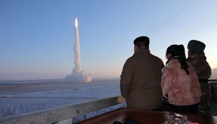 This picture released on December 19, 2023 shows North Korean leader Kim Jong Un (L) and his daughter watching the test launch of a Hwasongpho-18 intercontinental ballistic missile (ICBM) at an undisclosed location in North Korea. — AFP