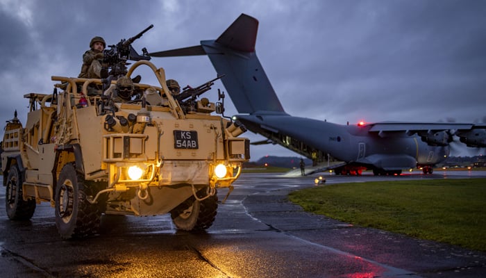 A Jackal vehicle drives on the runway away from an RAF grey plane in this image released on January 24, 2024. — X/@BritishArmy