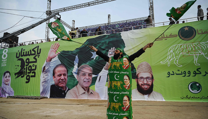 A supporter of the PMLN wears an outfit with portraits of the countrys former PM and party leaders Nawaz Sharif (R) and Shehbaz Sharif during an election campaign rally at Mansehra in KP on January 22, 2024. — AFP