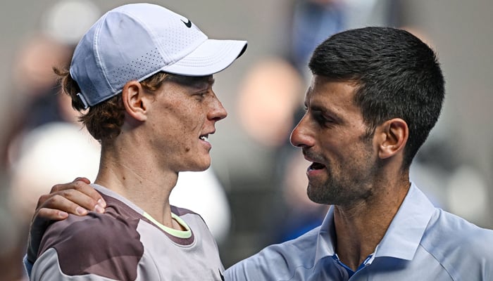 Italys Jannik Sinner greets Serbias Novak Djokovic (R) after victory in their mens singles semi-final match on day 13 of the Australian Open tennis tournament in Melbourne on January 26, 2024. — AFP